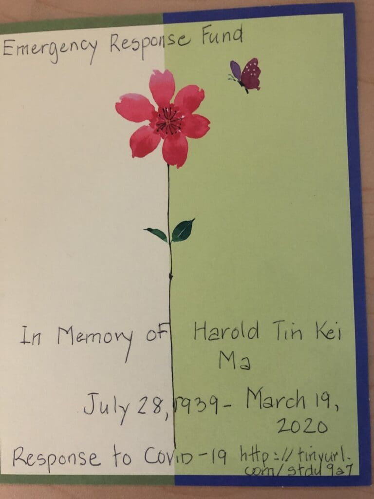 A photograph of a card with a flower and butterfly on it, and in hand writing it reads "Emergency Response Fund. In memory of Harold Tin Kei Ma. July 28, 1939 - March 19, 2020. Response to COVID-19 https://tinyurl.com/stdu9a7"