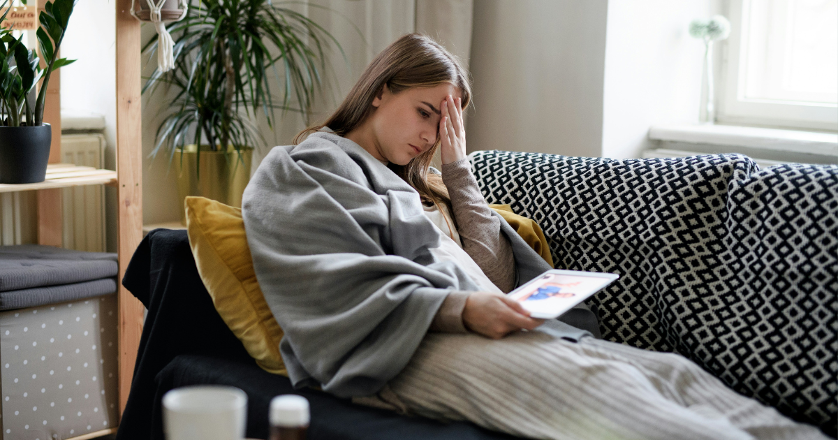 A woman sitting on a couch with the flu