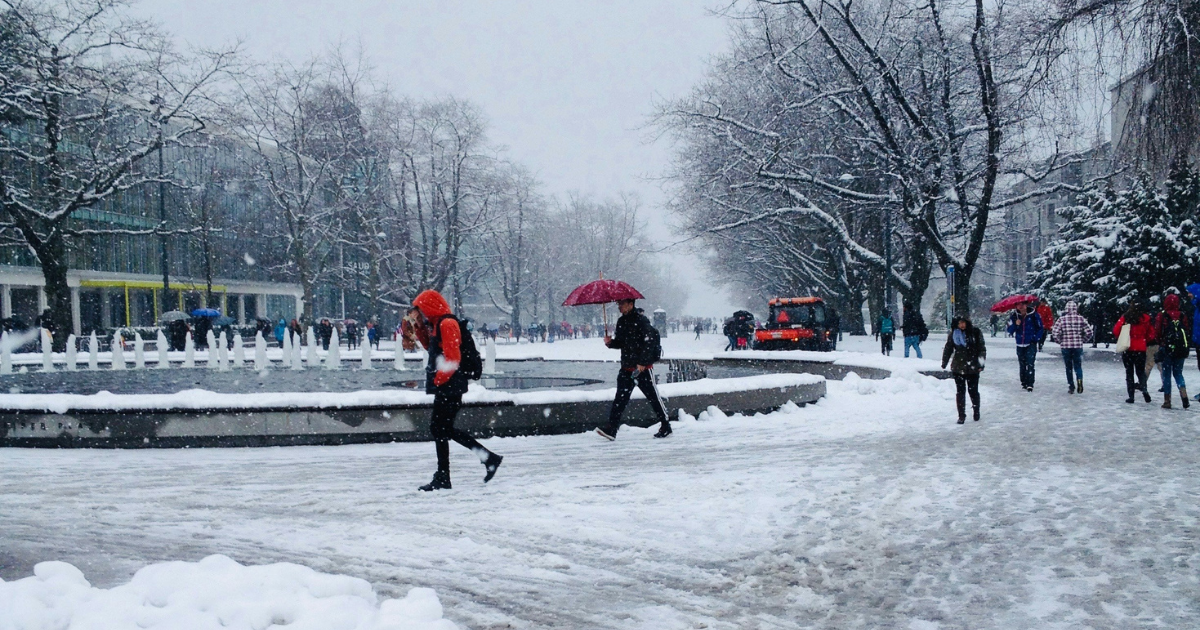 People walking in the snow and ice on a day with severe weather in BC