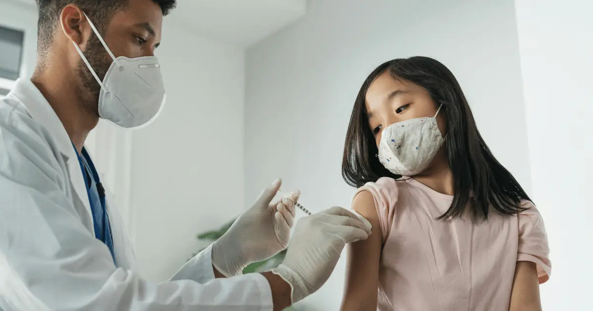 A child receiving a vaccine by a health care worker